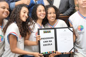 Estudante sorrindo ao segurar chave de carro, ilustrando o programa de CNH gratuita na Bahia para jovens da rede pública.