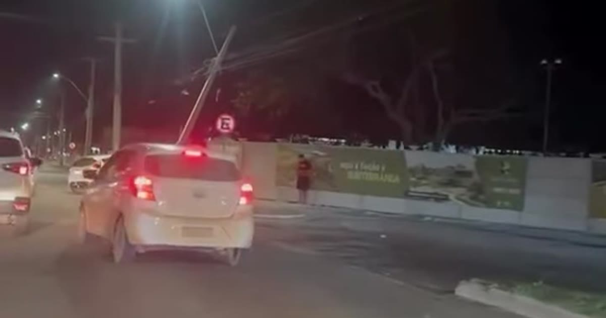 Carro parado próximo a poste danificado na Avenida Olívia Flores, em Vitória da Conquista