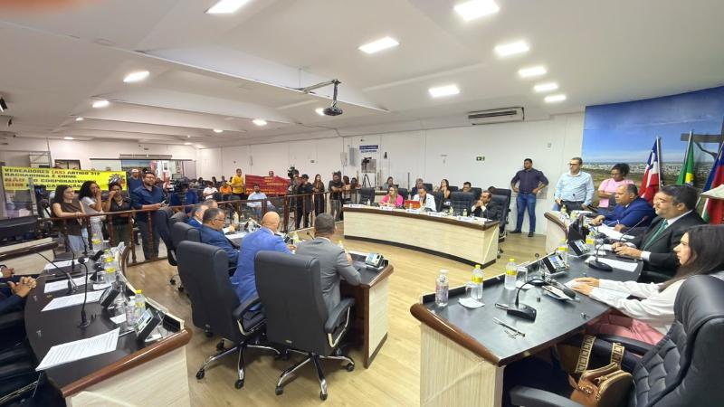 Vereadores sentados nas bancadas do plenário, com público acompanhando a sessão