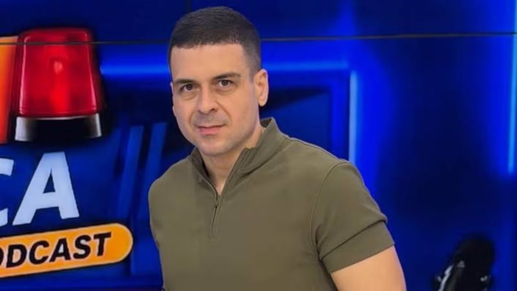 Marcelo Castro em estúdio, diante de cenário azul
