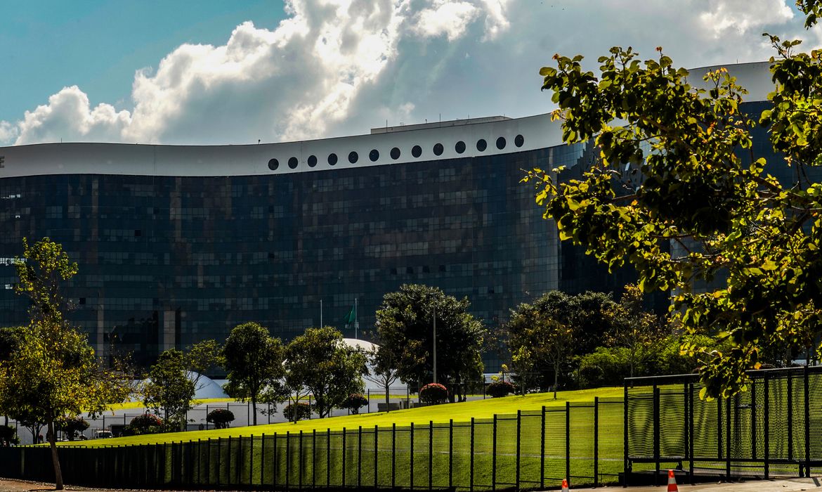 Edifício do Tribunal Superior Eleitoral com gramado e árvores à frente